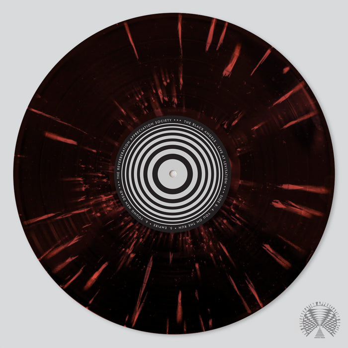 The Black Angels - Live At Levitation (Fuzz Club Edition) vinyl features a dark maroon background with bright orange streaks and a black and white concentric circle label, reflecting the vibrant energy of Austin live music.